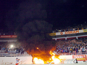 Sport devotees burn an offering of vanquished foes' property.